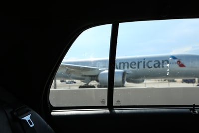 银色美国航空公司飞机从出租车窗口在迈阿密与蓝天